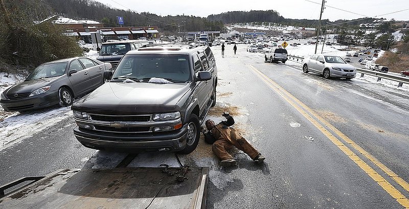 WINTER WEATHER ALHY115    .jpg :: Wrecker driver Shane Rhodes of Murray Towing hooks up an abandoned car left in the middle of US highway 78 as officials work to clear hundreds of abandoned vehicles Wednesday January 29,  2014 in Leeds,  Ala.  (AP Photo/Hal Yeager)