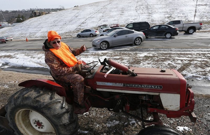 WINTER WEATHER ALHY118         .jpg :: Lee Robinson stops at a cluster of abandoned vehicles Wednesday January 29,  2014 in Leeds,  Alabama on US highway 78. Lee has been removing vehicles and clearing the road of ice, free of charge,  as he assists officials as they try to reopen numerous closed roads in the area. (AP Photo/Hal Yeager)