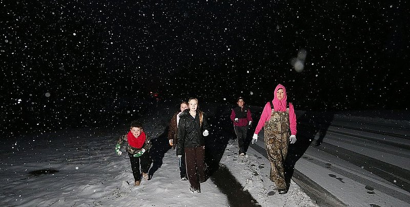 WINTER WEATHER ALHY120 9.53.43 PM.jpg :: Trevor Terrell, Sidlee Hill, Maylee Hill,  Cheyenne Terrell and Danielle Terrell walk along highway 35 as heavy snow falls Wednesday Feb. 12,  2014 in Fort Payne Ala.  Snowfall returned to the area after a day of light rain and is expected to add 4-6 inches to this area atop Lookout Mountain. (AP Photo/Hal Yeager)