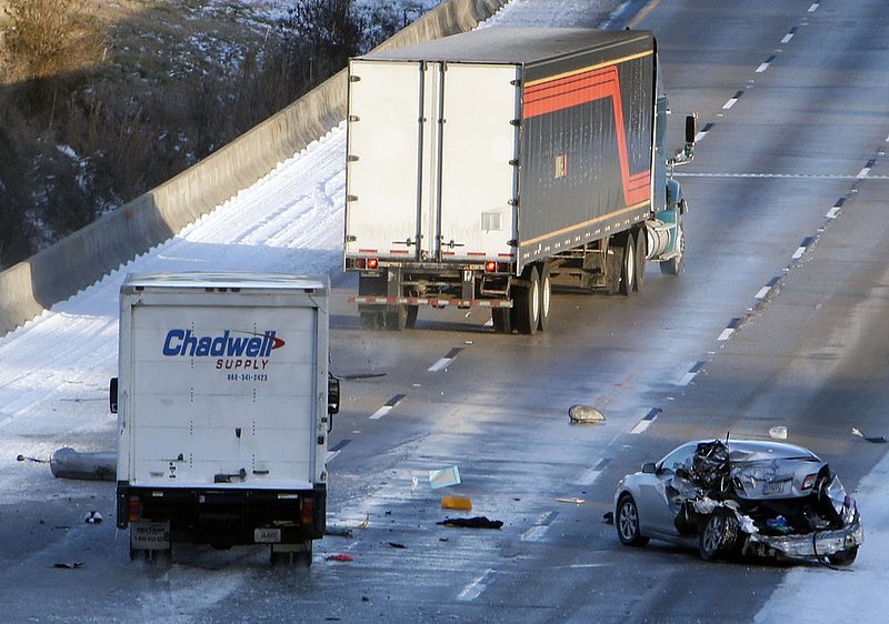 WINTER WEATHER ALHY126                 .jpg :: A tractor-trailer weaves after striking an abandoned car, lower right, on Interstate 20 Wednesday January 29,  2014 in Leeds,  Ala. The car was left in the middle of a bridge in the middle lane of the interstate. There were  no injuries. (AP Photo/Hal Yeager)
