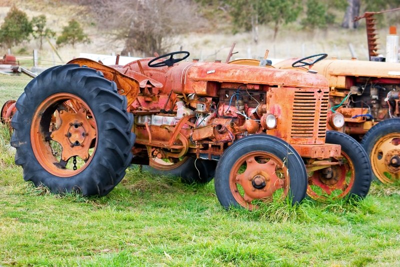 Australia 118.jpg :: A derelict tractor, with parts missing and wires hanging out, parked in a field