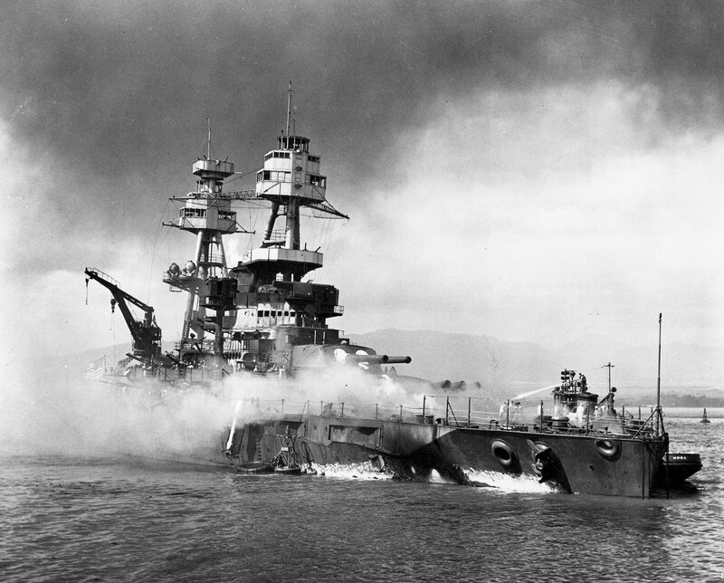 USS Nevada (BB-36) - N3061F.jpg :: USS Nevada (BB-36), Battleship, WW II - US NAVY PHOTO: USS Nevada (BB-36) beached and burning after being hit forward by Japanese bombs and torpedoes. Her pilothouse area is discolored by fires in that vicinity. The harbor tug Hoga (YT-146) is alongside Nevada's port bow, helping to fight fires on the battleship's forecastle. Note channel marker buoy against Nevada's starboard side, 7 Dec 1941.