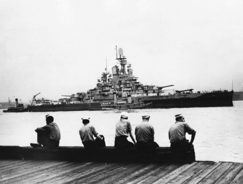 USS Nevada (BB-36) - N3063H.jpg :: USS Nevada (BB-36), Battleship, WW II - US NAVY PHOTO: A group of sailors survey the USS Nevada (BB-36), as she comes up the Hudson River. The first battleship to return from this summer's Normandy Invasion 6 Jun 1944. The 32,000-ton battleship, a veteran of World War I, served in the Attu Campaign, in the Pacific before being sent to the Atlantic. And she was at Pearl Harbor during the Jap Attack, being the only battleship to get underway. Her gun barrels were relined at New York, and she sailed for the Pacific, arriving off Iwo Jima 16 Feb 1945 to give marines invading and fighting ashore her massive gunfire support through 7 Mar. Note: This photo was censored before being released. Her SK-2 radar on the foretopmast has been obscured.