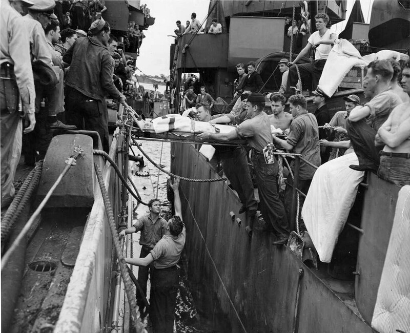 USS Nevada (BB-36) - N3064D.jpg :: USS Nevada (BB-36), Battleship, WW II - US NAVY PHOTO: Wounded men from the USS Nevada (BB-36) are transferred to an amphibious craft for further transfer to a Navy hospital ship. 11 men were killed, 41 wounded, when the big battleship was hit by a Jap suicide plane off Okinawa early in the morning of 27 Mar 1945.