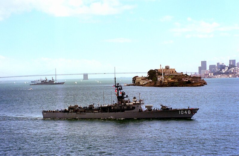 USS Sample (DE-1048) - N27022G.jpg :: USS Sample (DE-1048), Destroyer Escort, Vietnam War - US NAVY PHOTO:  1 Oct 1981: San Francisco Bay, Cal. - A starboard beam view of the USS Sample (FF-1048) underway during Fleet Week activities. Visible in the background are the San Francisco-Oakland Bay Bridge, Alcatraz Island, and the San Francisco skyline.