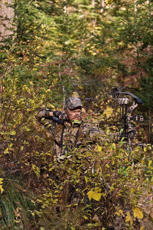 ©TC-Bowhunter-D90010-00597.jpg :: Bowhunter (wearing Advantage AP Brown Camo carrying a Hoyt Compound Bow) at full draw in timber and brush