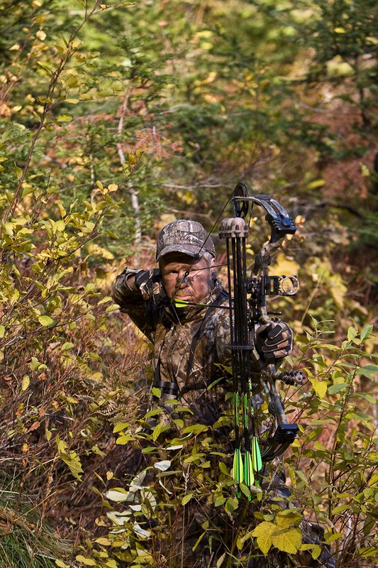 ©TC-Bowhunter-D90010-00600.jpg :: Bowhunter (wearing Advantage AP Brown Camo carrying a Hoyt Compound Bow) at full draw in timber and brush