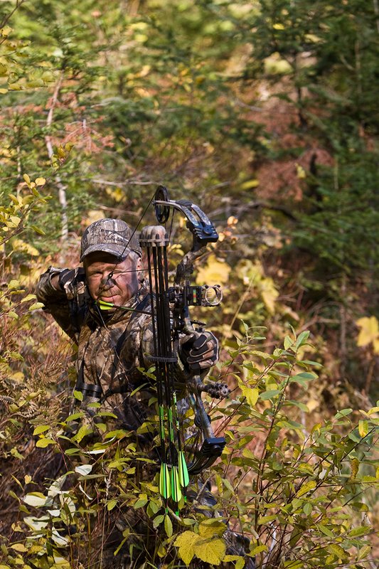 ©TC-Bowhunter-D90010-00606.jpg :: Bowhunter (wearing Advantage AP Brown Camo carrying a Hoyt Compound Bow) at full draw in timber and brush