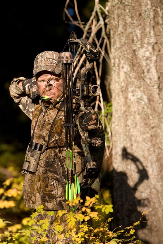 ©TC-Bowhunter-D90010-00642.jpg :: Bowhunter (wearing Advantage AP Brown Camo carrying a Hoyt Compound Bow) at full draw in timber and brush