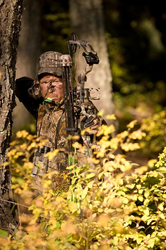 ©TC-Bowhunter-D90010-00645.jpg :: Bowhunter (wearing Advantage AP Brown Camo carrying a Hoyt Compound Bow) at full draw in timber and brush