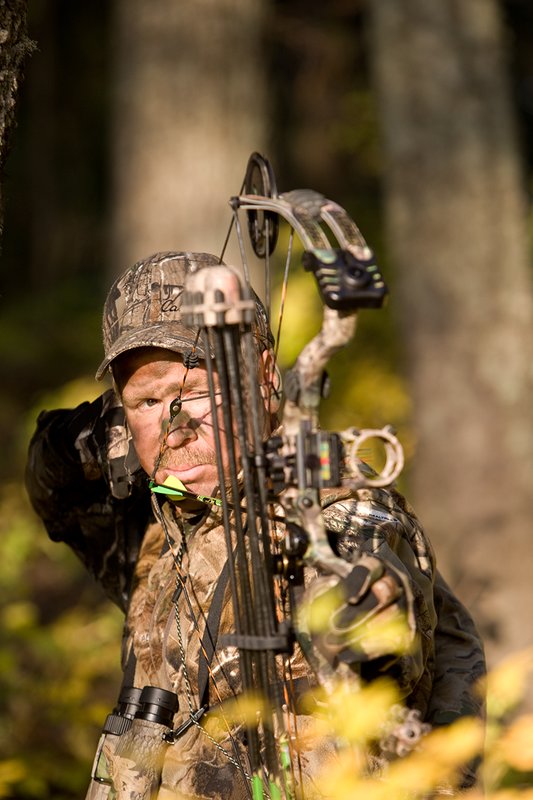 ©TC-Bowhunter-D90010-00654.jpg :: Bowhunter (wearing Advantage AP Brown Camo carrying a Hoyt Compound Bow) at full draw in timber and brush