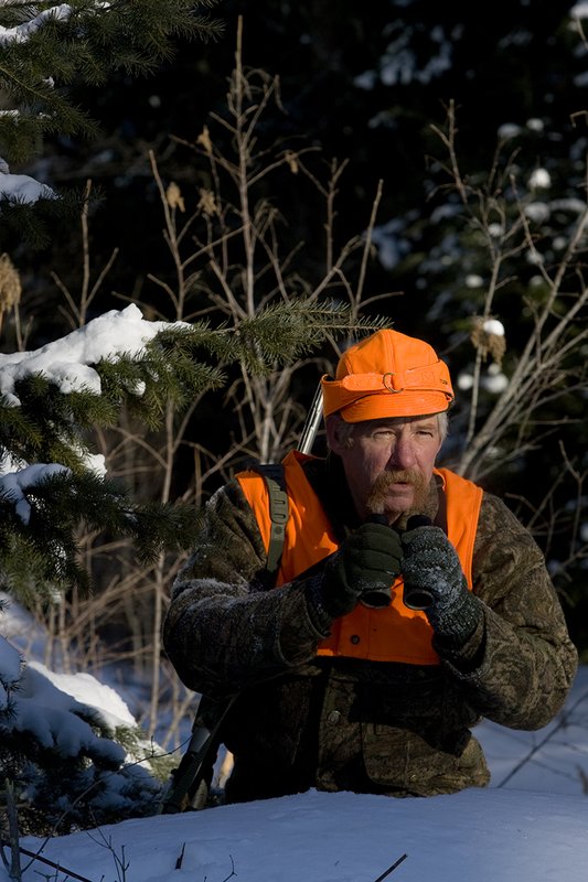 ©TC-Muzzleloader Hunter In Snow-D90008-00001.jpg :: Muzzleloader hunter in snow wearing Filson Wool Clothes in Advantage Timber Camoflage with florescent orange vest and hat shooting CVA Muzzleloader topped with Nikon Omega Muzzleloader scope