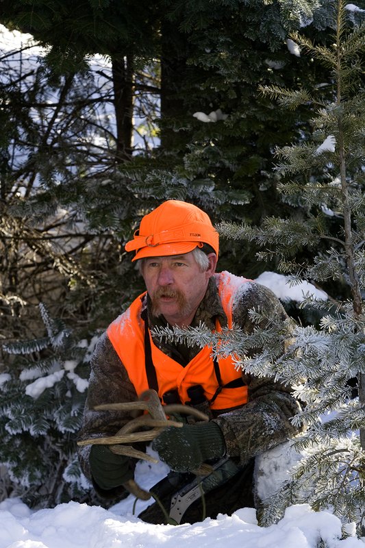 ©TC-Muzzleloader Hunter In Snow-D90008-00007.jpg :: Muzzleloader hunter in snow wearing Filson Wool Clothes in Advantage Timber Camoflage with florescent orange vest and hat shooting CVA Muzzleloader topped with Nikon Omega Muzzleloader scope