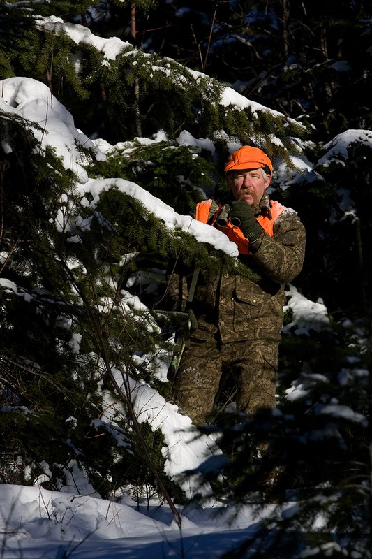 ©TC-Muzzleloader Hunter In Snow-D90008-00015.jpg :: Muzzleloader hunter in snow wearing Filson Wool Clothes in Advantage Timber Camoflage with florescent orange vest and hat shooting CVA Muzzleloader topped with Nikon Omega Muzzleloader scope