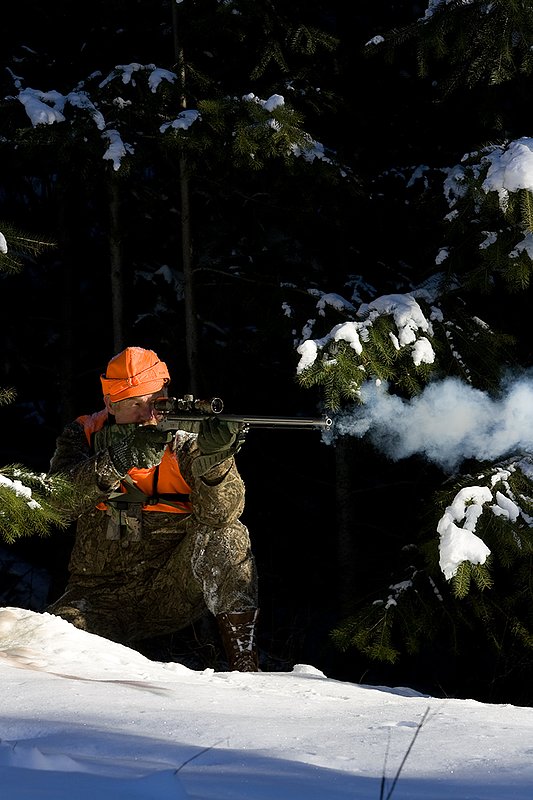 ©TC-Muzzleloader Hunter In Snow-D90008-00029.jpg :: Muzzleloader hunter in snow wearing Filson Wool Clothes in Advantage Timber Camoflage with florescent orange vest and hat shooting CVA Muzzleloader topped with Nikon Omega Muzzleloader scope