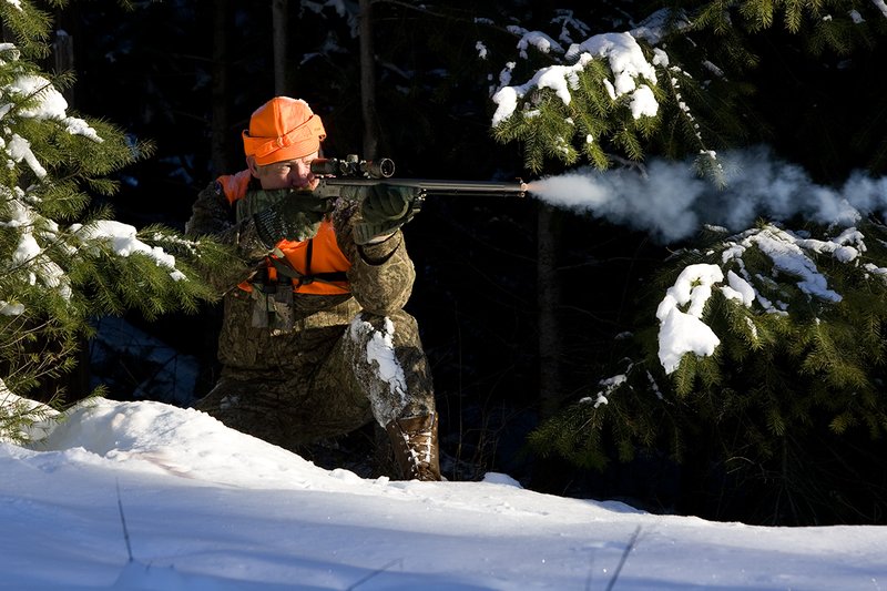 ©TC-Muzzleloader Hunter In Snow-D90008-00037.jpg :: Muzzleloader hunter in snow wearing Filson Wool Clothes in Advantage Timber Camoflage with florescent orange vest and hat shooting CVA Muzzleloader topped with Nikon Omega Muzzleloader scope