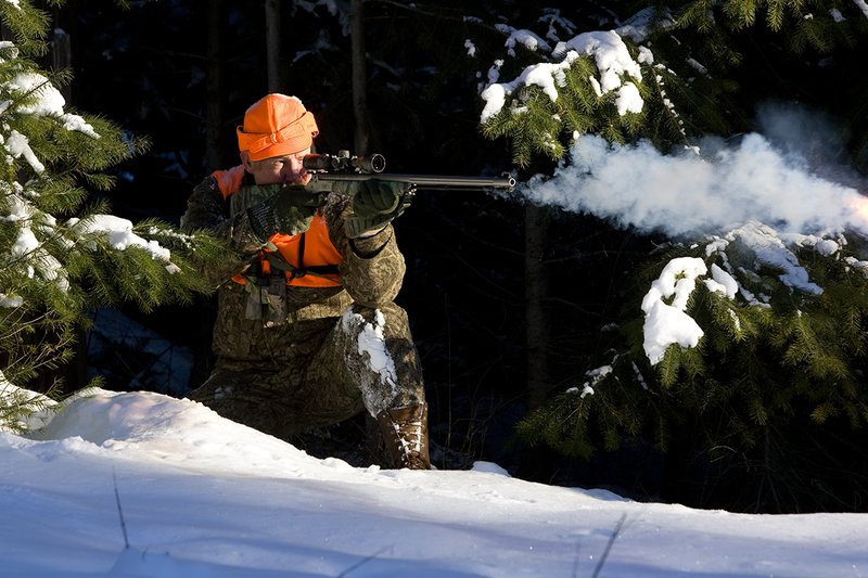 ©TC-Muzzleloader Hunter In Snow-D90008-00039.jpg :: Muzzleloader hunter in snow wearing Filson Wool Clothes in Advantage Timber Camoflage with florescent orange vest and hat shooting CVA Muzzleloader topped with Nikon Omega Muzzleloader scope