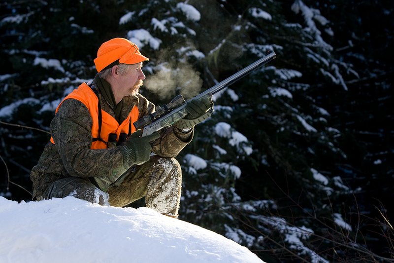 ©TC-Muzzleloader Hunter In Snow-D90008-00054.jpg :: Muzzleloader hunter in snow wearing Filson Wool Clothes in Advantage Timber Camoflage with florescent orange vest and hat shooting CVA Muzzleloader topped with Nikon Omega Muzzleloader scope