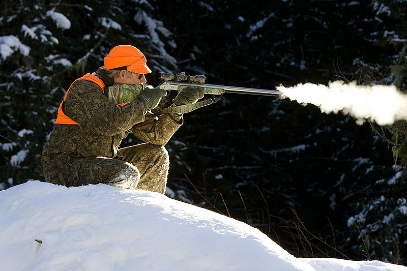 ©TC-Muzzleloader Hunter In Snow-D90008-00058.jpg :: Muzzleloader hunter in snow wearing Filson Wool Clothes in Advantage Timber Camoflage with florescent orange vest and hat shooting CVA Muzzleloader topped with Nikon Omega Muzzleloader scope