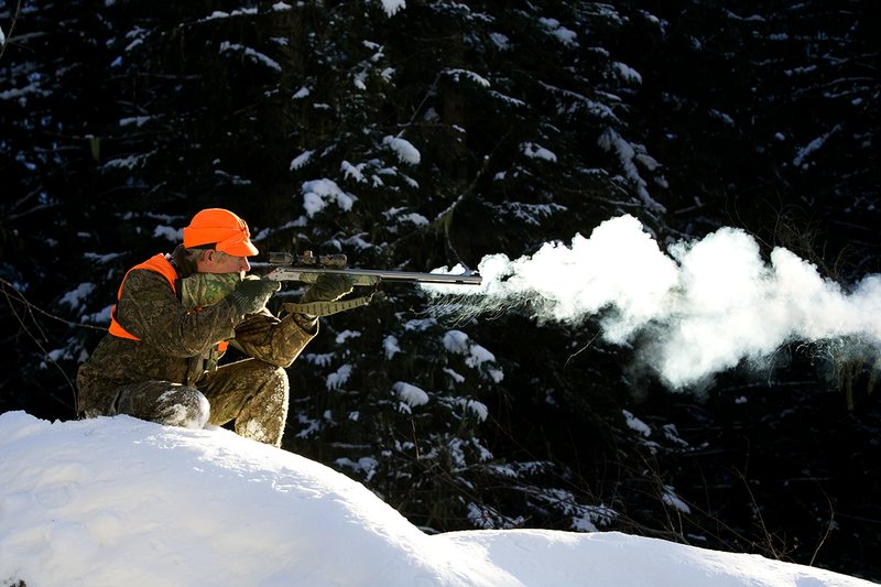 ©TC-Muzzleloader Hunter In Snow-D90008-00067.jpg :: Muzzleloader hunter in snow wearing Filson Wool Clothes in Advantage Timber Camoflage with florescent orange vest and hat shooting CVA Muzzleloader topped with Nikon Omega Muzzleloader scope