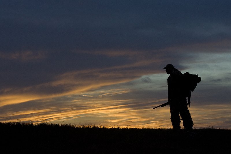 ©TC-Turkey Hunting-D90006-00366.jpg :: Turkey Hunter with long bearded gobbler silhouteed against setting sun.