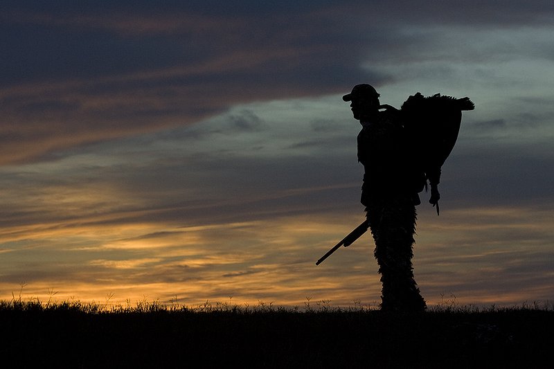 ©TC-Turkey Hunting-D90006-00372.jpg :: Turkey Hunter with long bearded gobbler silhouteed against setting sun.
