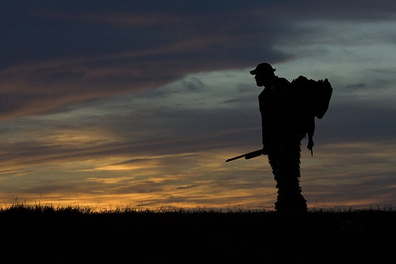 ©TC-Turkey Hunting-D90006-00378.jpg :: Turkey Hunter with long bearded gobbler silhouteed against setting sun.