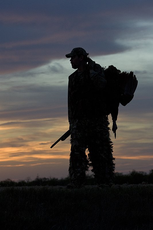©TC-Turkey Hunting-D90006-00384.jpg :: Turkey Hunter with long bearded gobbler silhouteed against setting sun.