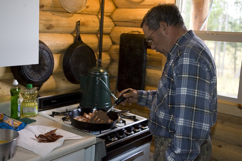 ©TC_Hunting Camps-D80003-107.jpg :: Elk Camp, cooking bacon and eggs on stove for breakfast in elk camp