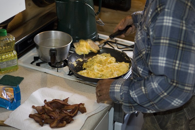©TC_Hunting Camps-D80003-113.jpg :: Elk Camp, cooking bacon and eggs on stove for breakfast in elk camp