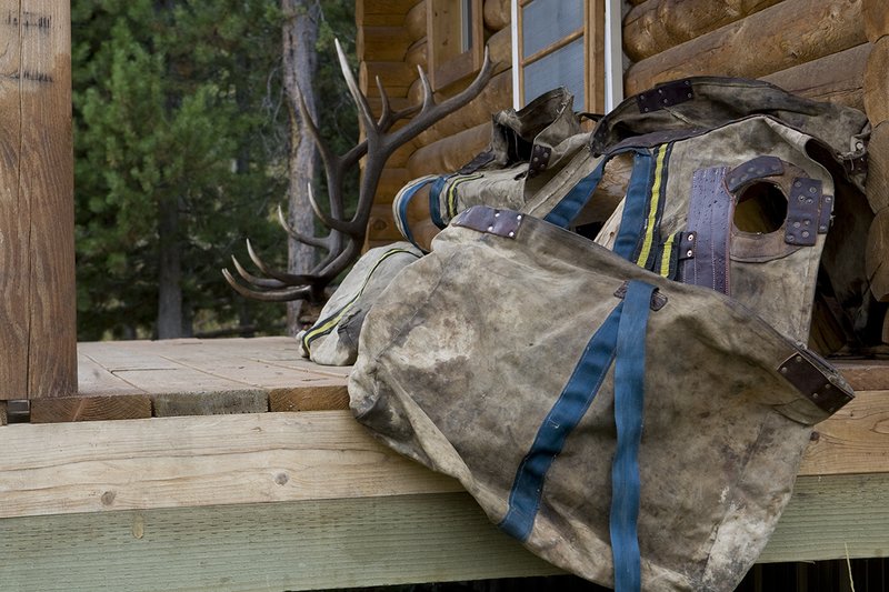 ©TC_Hunting Camps-D80003-128.jpg :: Elk Camp, cabin in woods, with elk rack on porch, panniers for carrying elk quarters,