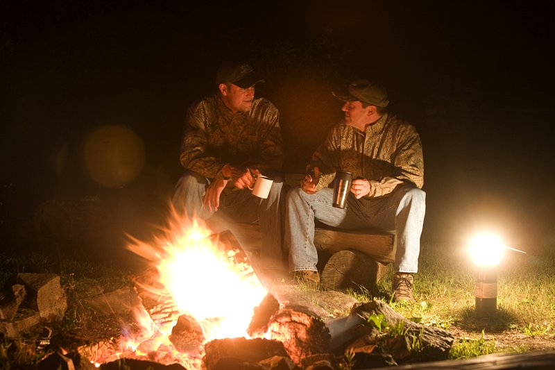 ©TC_Hunting Camps-D80003-240.jpg :: Dudley McGarity(rt) and Adam Heggenstaller sit in front of hunting campfire and discuss the days hunt.