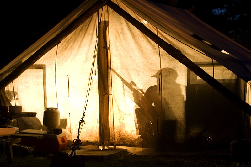 ©TC_Hunting Camps-D80003-255.jpg :: Hunters in wall tent, silhouetted in light from lantern
