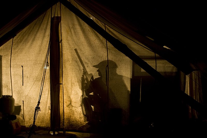 ©TC_Hunting Camps-D80003-265.jpg :: Hunters in wall tent, silhouetted in light from lantern