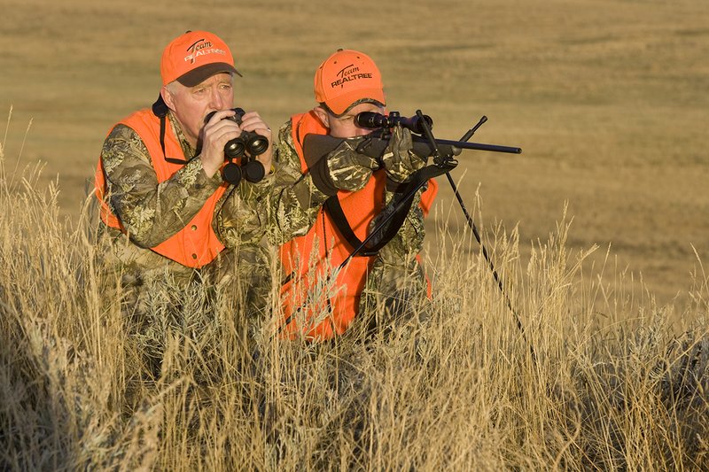 ©TC_Prairie Rifle Hunter-D89991-225.jpg :: Rifle hunter(s) on prairie, wearing Advantage Max-1HD camo, with a florescent orange vest, Bushnell Elite 3x9 Rifle sclope, Elite Binoculars