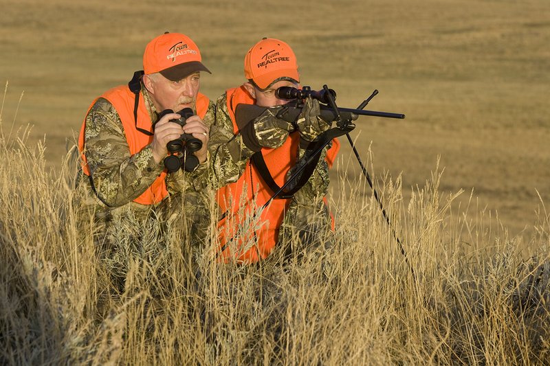 ©TC_Prairie Rifle Hunter-D89991-228.jpg :: Rifle hunter(s) on prairie, wearing Advantage Max-1HD camo, with a florescent orange vest, Bushnell Elite 3x9 Rifle sclope, Elite Binoculars