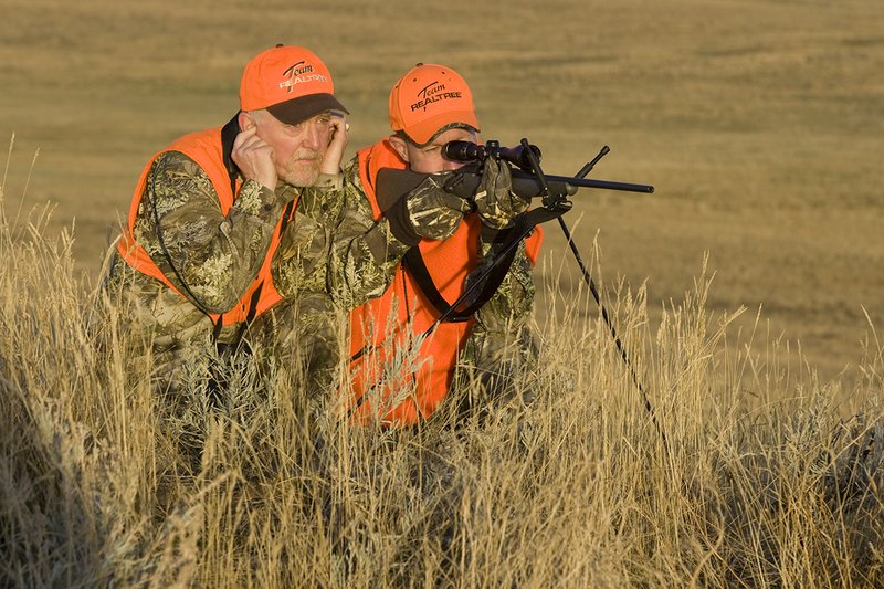©TC_Prairie Rifle Hunter-D89991-231.jpg :: Rifle hunter(s) on prairie, wearing Advantage Max-1HD camo, with a florescent orange vest, Bushnell Elite 3x9 Rifle sclope, Elite Binoculars