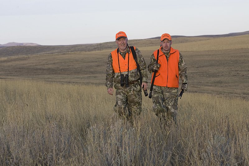 ©TC_Prairie Rifle Hunter-D89991-240.jpg :: Rifle hunter(s) on prairie, wearing Advantage Max-1HD camo, with a florescent orange vest, Bushnell Elite 3x9 Rifle sclope, Elite Binoculars
