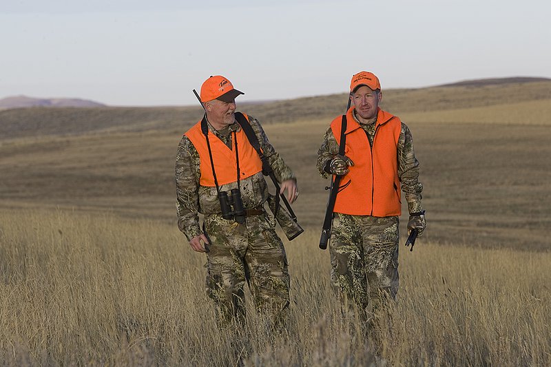 ©TC_Prairie Rifle Hunter-D89991-251.jpg :: Rifle hunter(s) on prairie, wearing Advantage Max-1HD camo, with a florescent orange vest, Bushnell Elite 3x9 Rifle sclope, Elite Binoculars