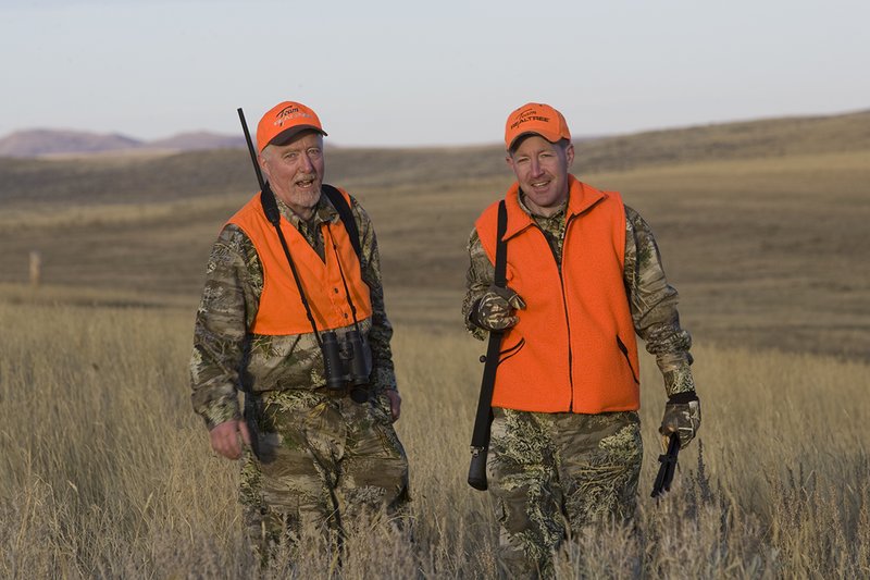 ©TC_Prairie Rifle Hunter-D89991-257.jpg :: Rifle hunter(s) on prairie, wearing Advantage Max-1HD camo, with a florescent orange vest, Bushnell Elite 3x9 Rifle sclope, Elite Binoculars