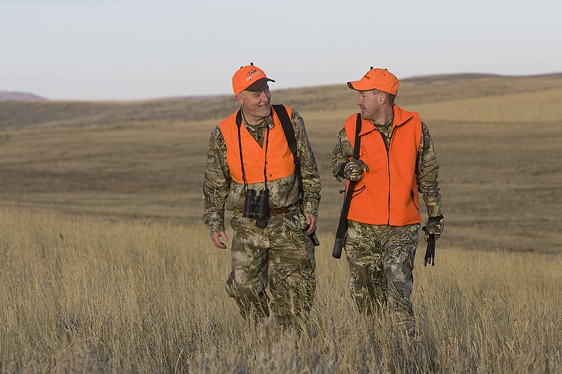 ©TC_Prairie Rifle Hunter-D89991-260.jpg :: Rifle hunter(s) on prairie, wearing Advantage Max-1HD camo, with a florescent orange vest, Bushnell Elite 3x9 Rifle sclope, Elite Binoculars
