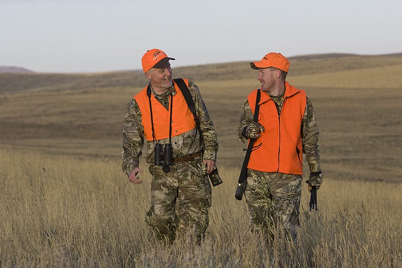 ©TC_Prairie Rifle Hunter-D89991-263.jpg :: Rifle hunter(s) on prairie, wearing Advantage Max-1HD camo, with a florescent orange vest, Bushnell Elite 3x9 Rifle sclope, Elite Binoculars