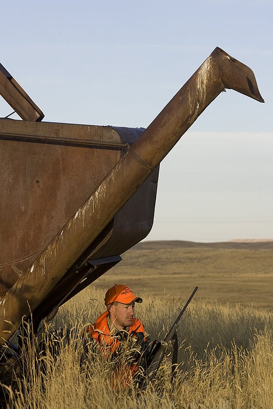 ©TC_Prairie Rifle Hunter-D89991-272.jpg :: Rifle hunter(s) on prairie, wearing Advantage Max-1HD camo, with a florescent orange vest, Bushnell Elite 3x9 Rifle sclope, Elite Binoculars
