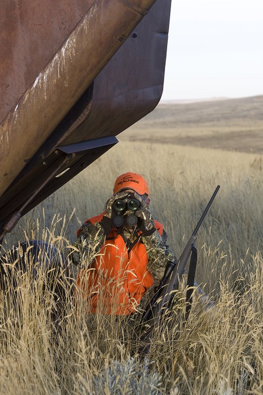 ©TC_Prairie Rifle Hunter-D89991-275.jpg :: Rifle hunter(s) on prairie, wearing Advantage Max-1HD camo, with a florescent orange vest, Bushnell Elite 3x9 Rifle sclope, Elite Binoculars
