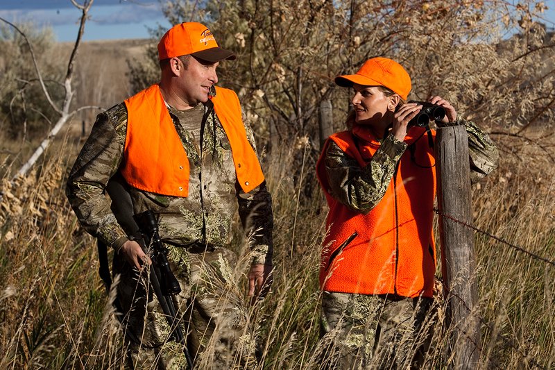 TC-Hunt-Women Big Game-D89992-00199.jpg :: Woman and man rifle hunting, river bottom, cottonwood trees, Max 1 camo, orange vest, hat, Elite Bushnell optics