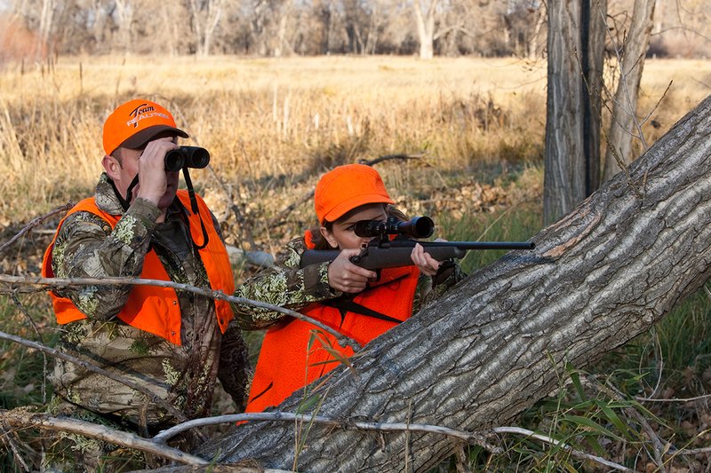 TC-Hunt-Women Big Game-D89992-00254.jpg :: Woman and man rifle hunting, river bottom, cottonwood trees, Max 1 camo, orange vest, hat, Elite Bushnell optics