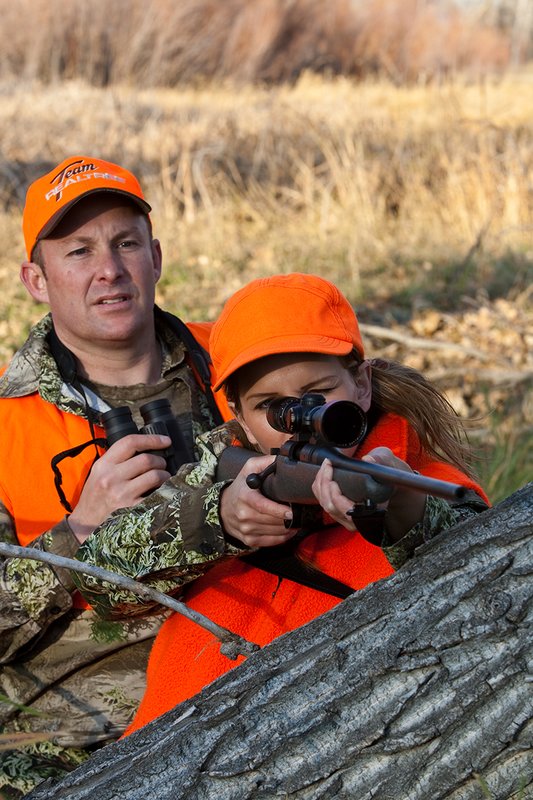 TC-Hunt-Women Big Game-D89992-00256.jpg :: Woman and man rifle hunting, river bottom, cottonwood trees, Max 1 camo, orange vest, hat, Elite Bushnell optics