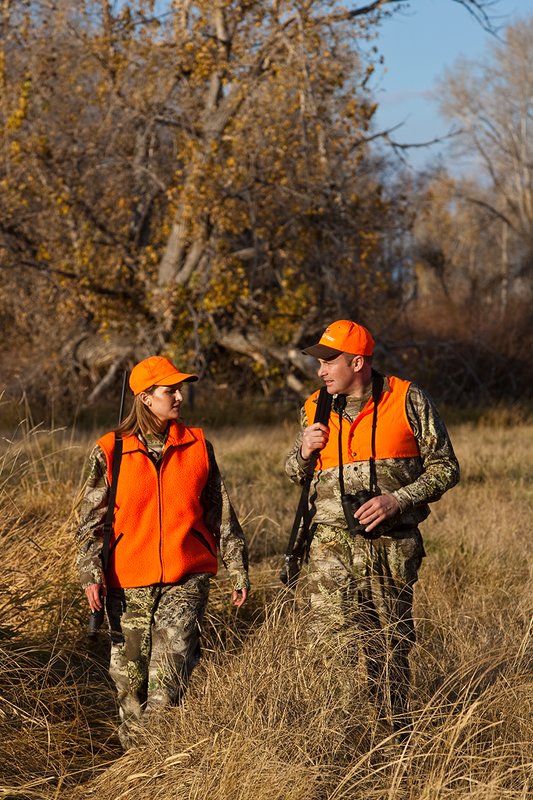 TC-Hunt-Women Big Game-D89992-00280.jpg :: Woman and man rifle hunting, river bottom, cottonwood trees, Max 1 camo, orange vest, hat, Elite Bushnell optics