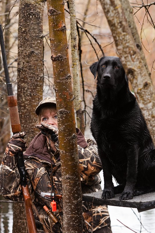 TC-Hunt-Women Waterfowl-D90081-00064.jpg :: Women Hunting Waterfowl in Flooded Timber, Advantage MaX-4HD Camo, Black Lab dog on platform