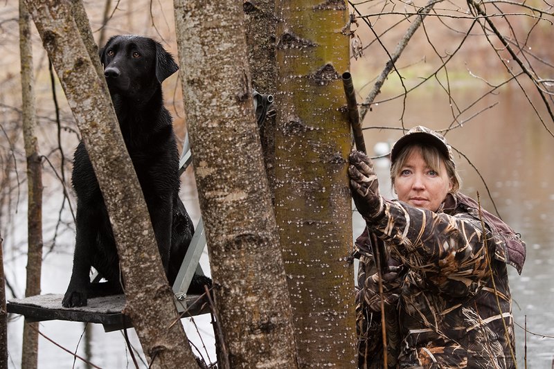 TC-Hunt-Women Waterfowl-D90081-00078.jpg :: Women Hunting Waterfowl in Flooded Timber, Advantage MaX-4HD Camo, Black Lab dog on platform